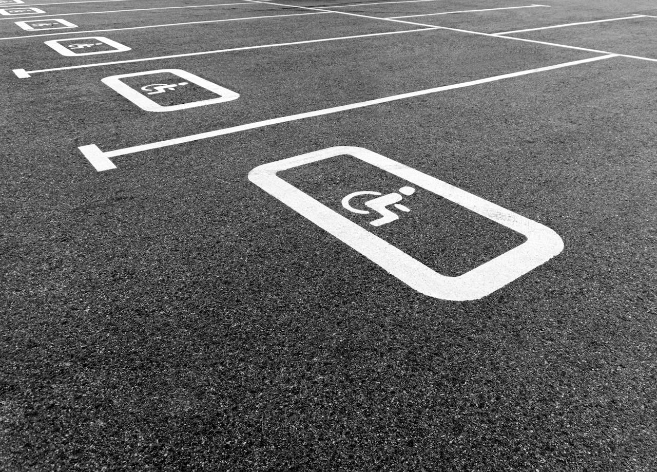 A black and white photo of a parking lot highlighting a disabled parking space.
